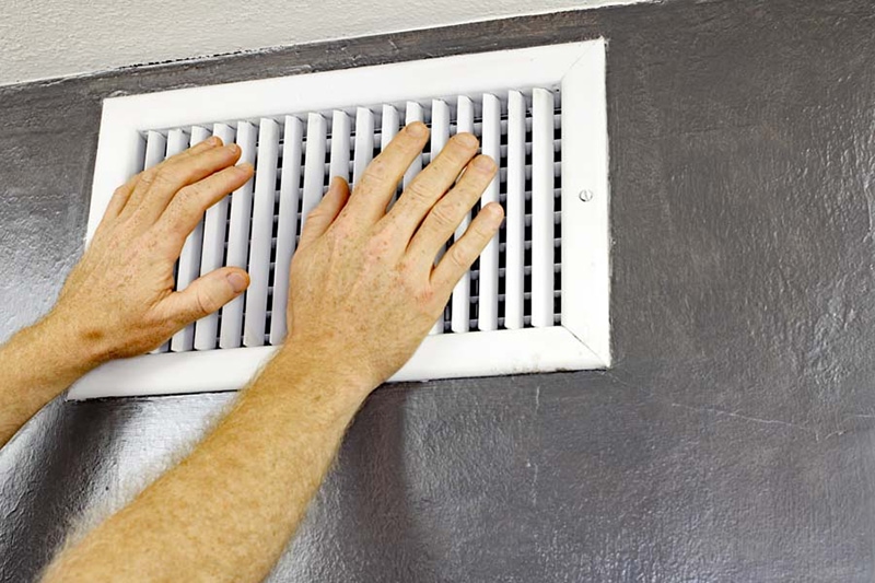 ac blowing hot air, two hands in front of an ac vent