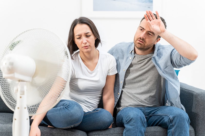 When Do I Replace My Air Conditioner in Mount Sterling? Couple trying to refresh during summer heat wave.
